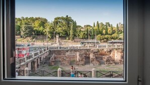 A view of ancient ruins with a bridge and trees in the background. - First Floor (Rome)