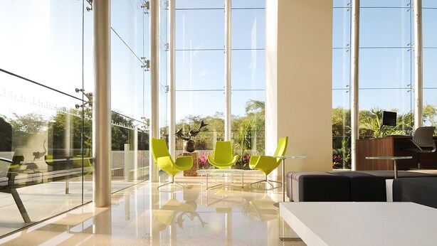 A modern interior with large windows, a glass table, and bright green chairs. - Holiday Inn Express Puerto Vallarta by IHG (Puerto Vallarta)