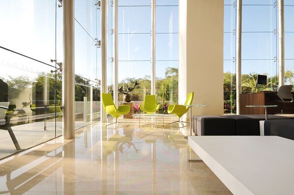 A modern interior with large windows, a glass table, and bright green chairs. - Holiday Inn Express Puerto Vallarta by IHG (Puerto Vallarta)