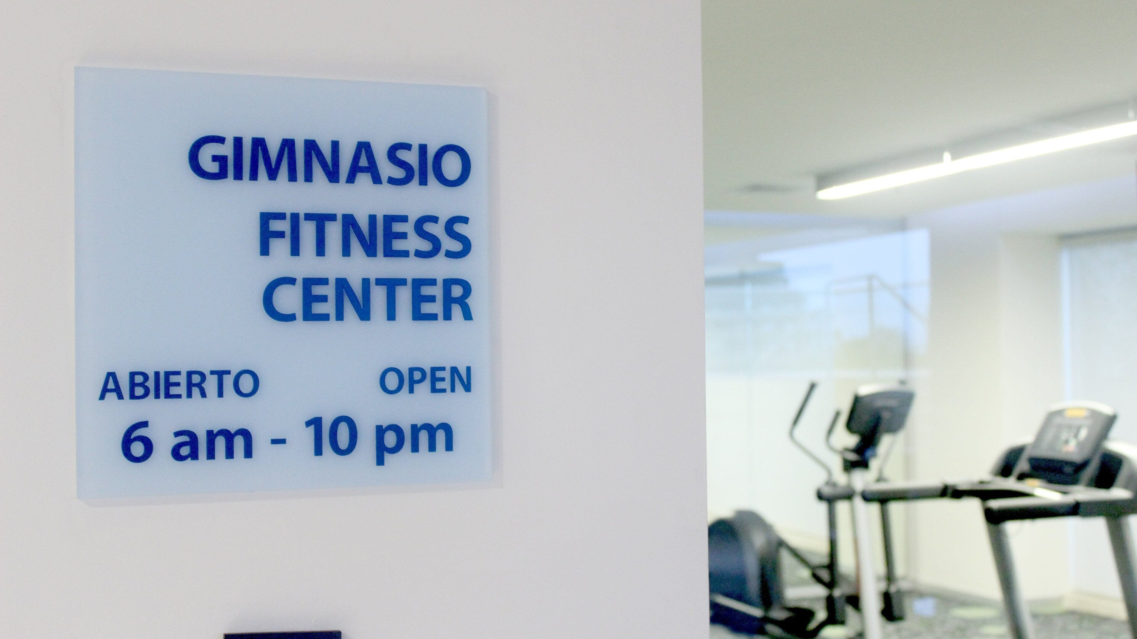 A sign for a gymnasium fitness center open from 6 am to 10 pm.