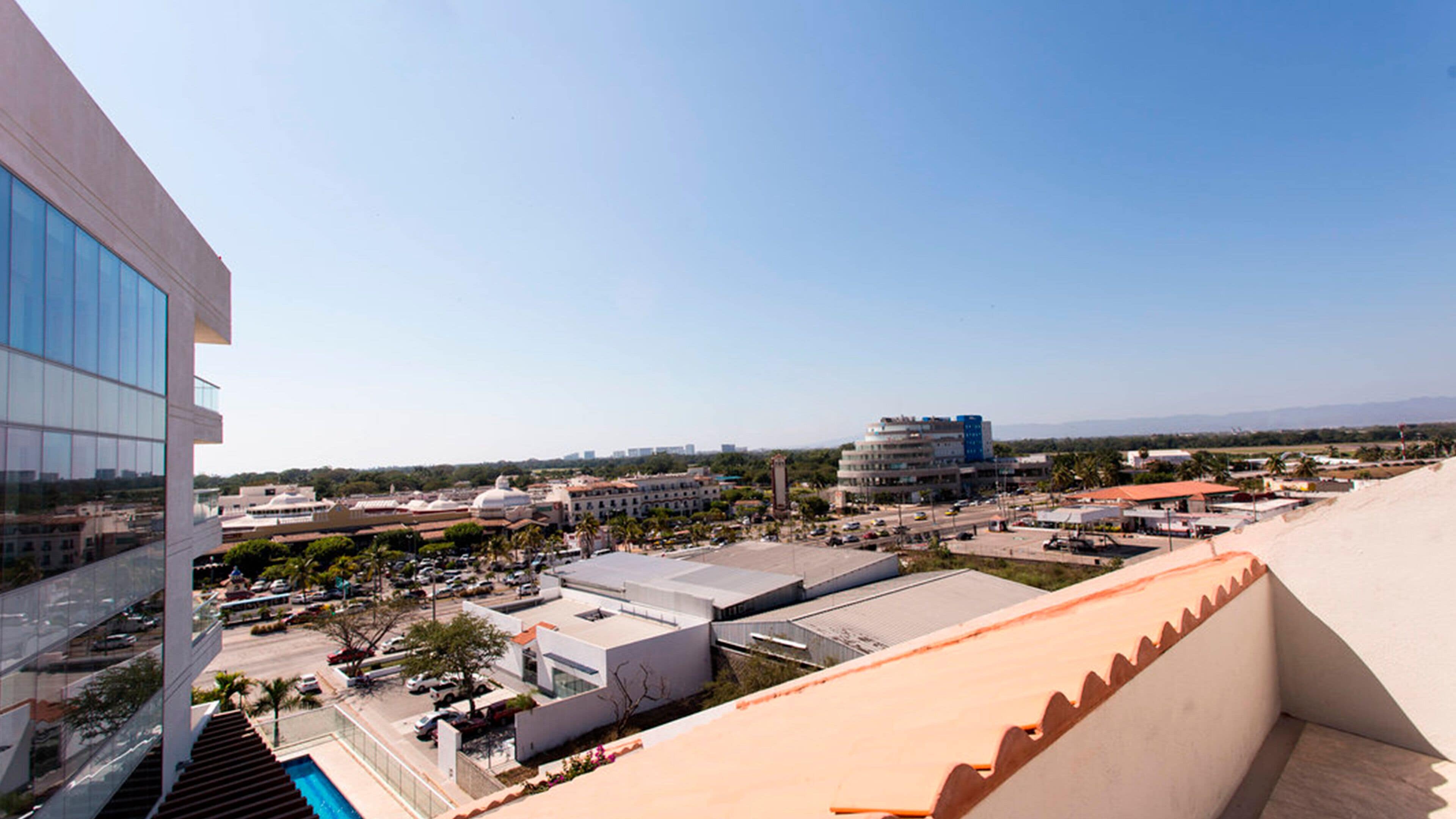 A modern building with a glass facade and a pool area.
