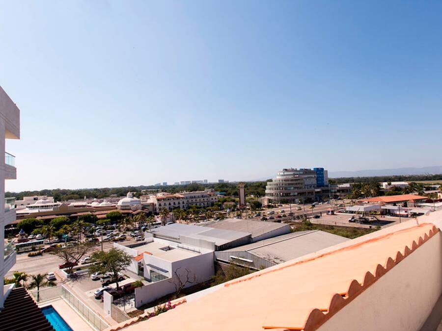 A modern building with a glass facade and a pool area.