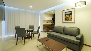 A modern living room with a sofa, a coffee table, and a dining area with chairs and a table. - Holiday Inn Express Puerto Vallarta by IHG (Puerto Vallarta)