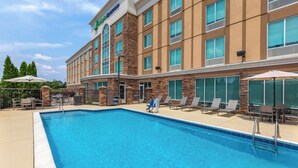 Un hôtel doté d’une piscine, d’un espace extérieur aménagé et d’une façade en pierre.