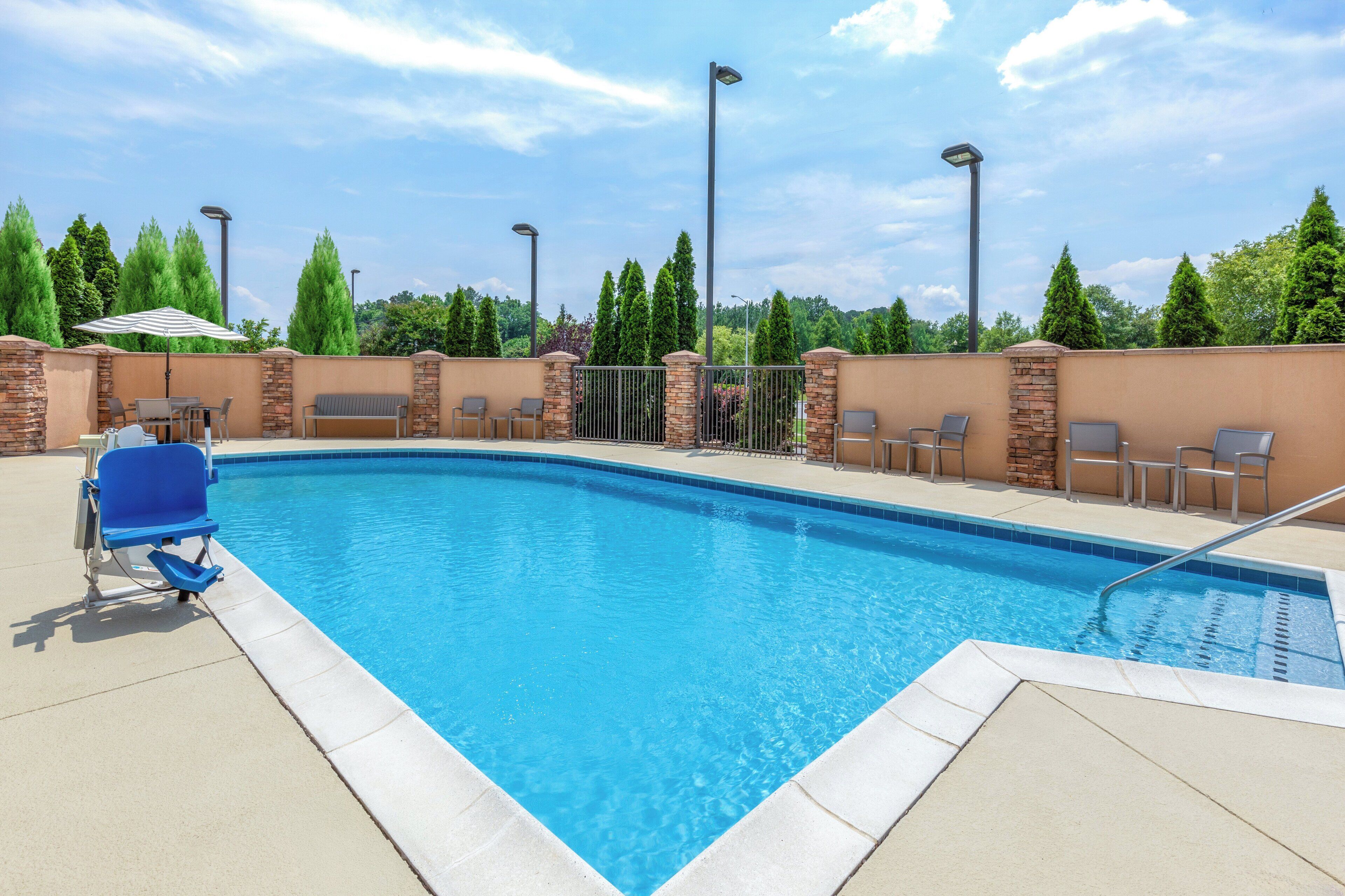 Een seizoensgebonden buitenzwembad en ligstoelen