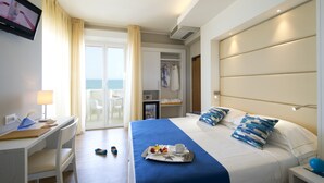 A hotel room with a bed, a desk, a chair, a TV, and a view of the sea. - UNAWAY Imperial Beach Fano (Fano)
