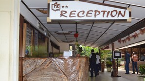 Ett receptionsområde med en marmorskiva, en skylt med texten ”RECEPTION” och ett tak med ett rutmönster.