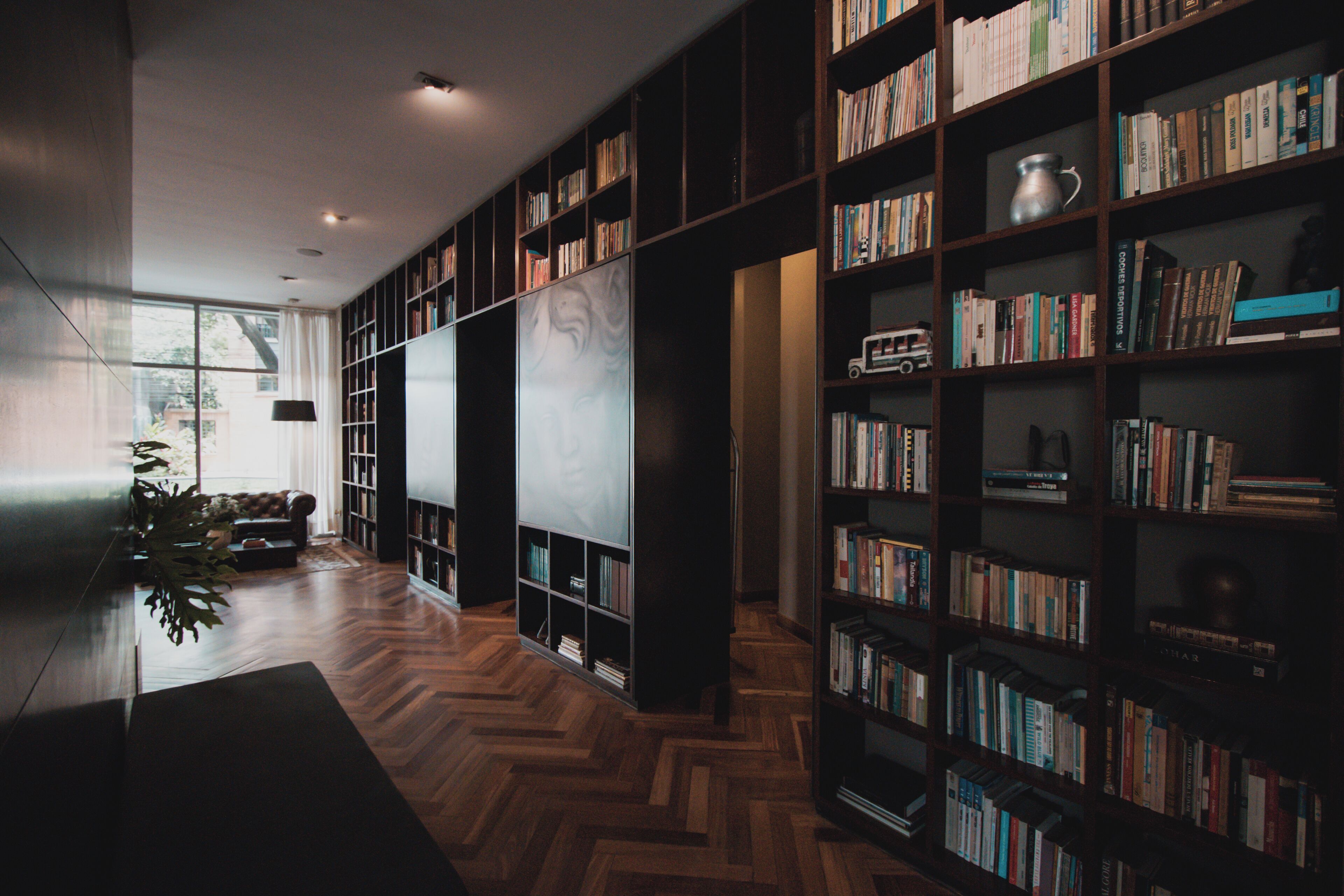A modern library with wooden floors and bookshelves filled with books.
