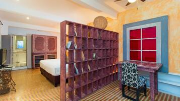 A room with a bed, a desk, a chair, a bookshelf, and a window with red panes.