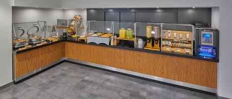 A modern breakfast bar with self-service options, including a coffee machine and various food items.
