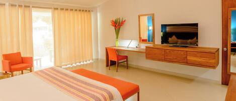 A hotel room with a bed, a desk with a laptop, a television, and a chair.