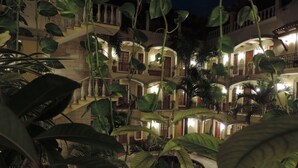 Un hôtel à plusieurs étages doté de balcons et d’une végétation luxuriante.