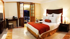 Une chambre d’hôtel avec un lit, un bureau et une télévision.