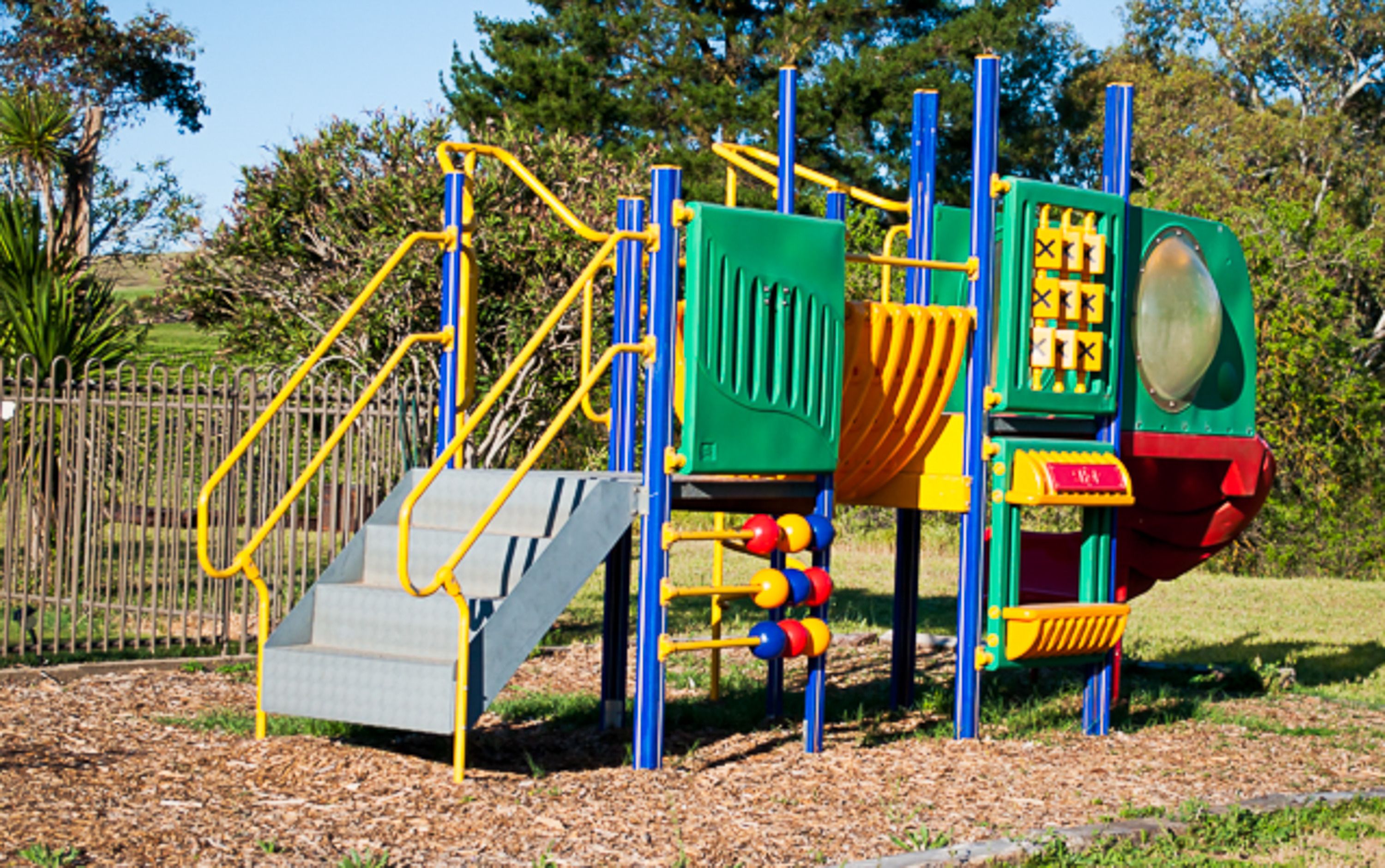 Un parque infantil con tobogán, estructuras para escalar y una piscina de pelotas.