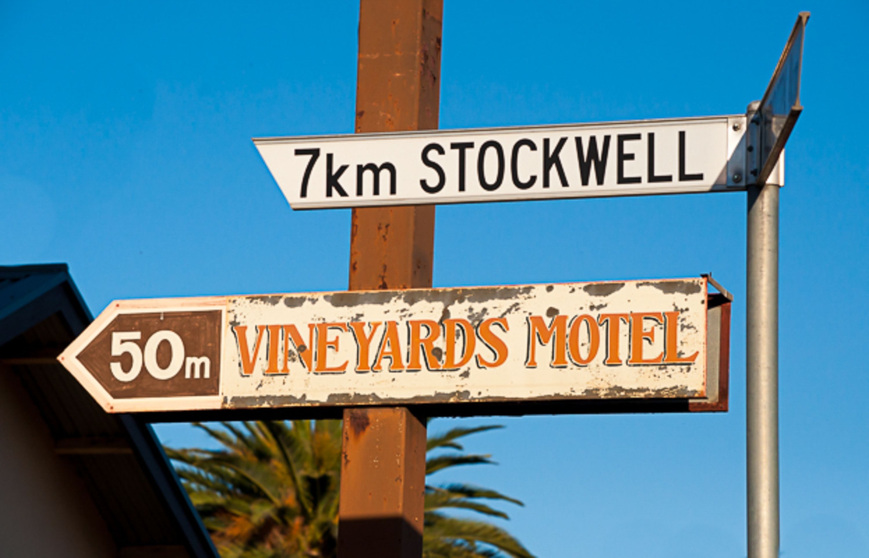A directional sign with "7km STOCKWELL" and "50m VINEYARDS MOTEL" pointing in different directions.