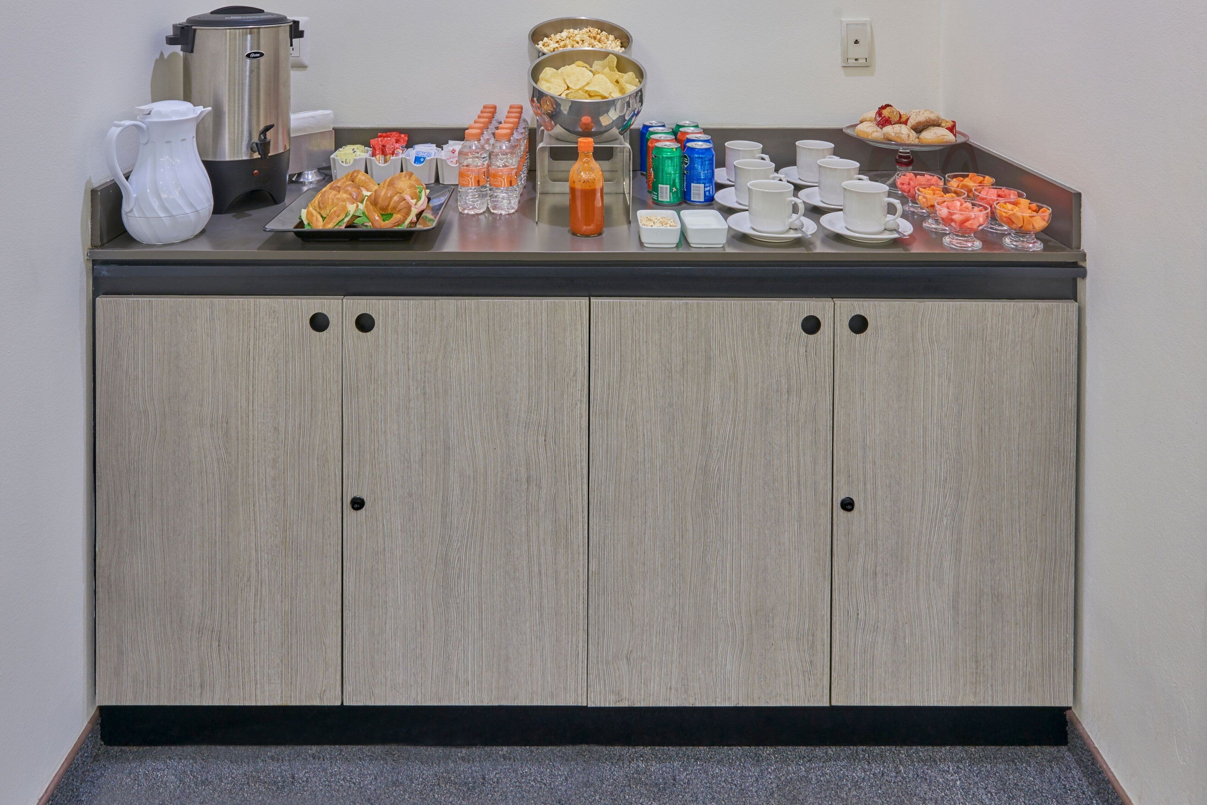 A buffet setup with a coffee station, snacks, and beverages.