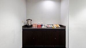 Una kitchenette con cafetera, botellas de agua y tostadora.