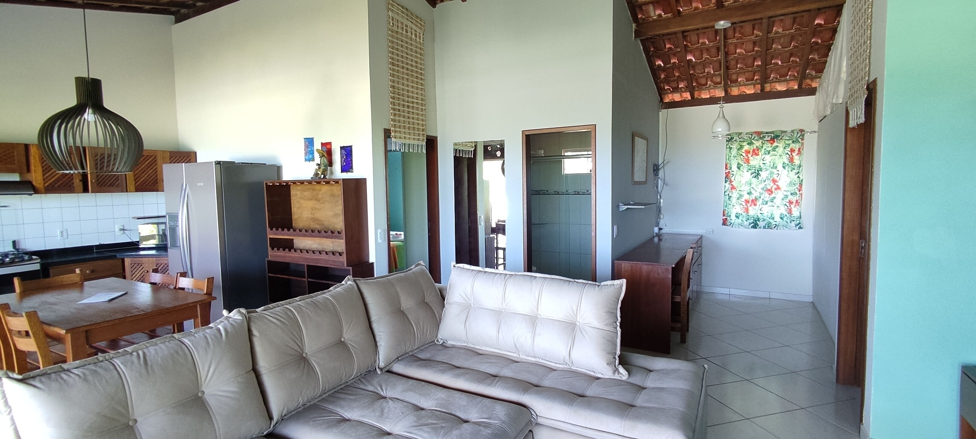 Una sala de estar con sofá, mesa de comedor y zona de cocina.
