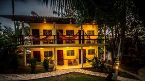 A two-story house with a patio, hammocks, and a satellite dish. - Pousada Cavalo Marinho (Tibau do Sul)