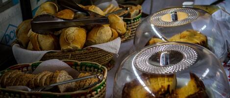 A buffet table with baskets of bread and a covered dish.