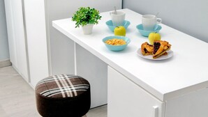 A white table with a plant, bowls of fruit, cereal, and a slice of pie. - Domus Domas & Boutique   (Rome)