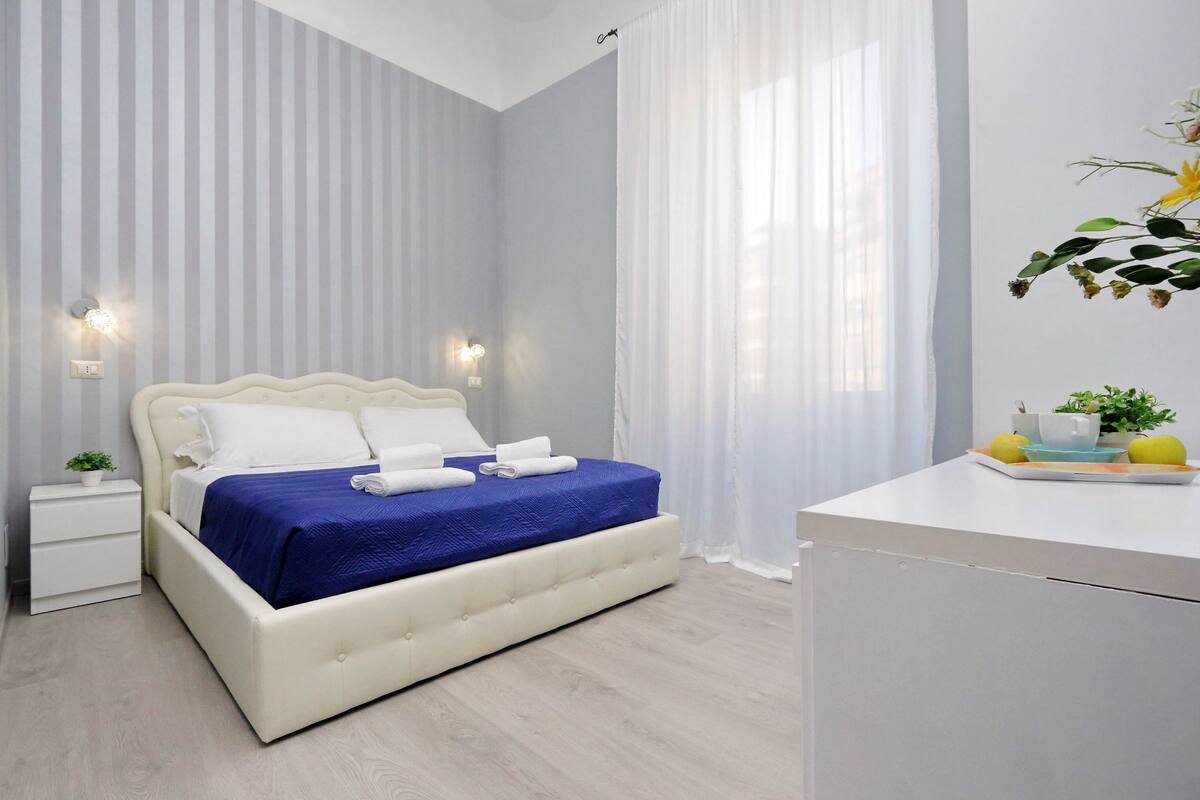 Ein modernes Schlafzimmer mit einem großen Bett, Nachttischen und einem Beistelltisch.
