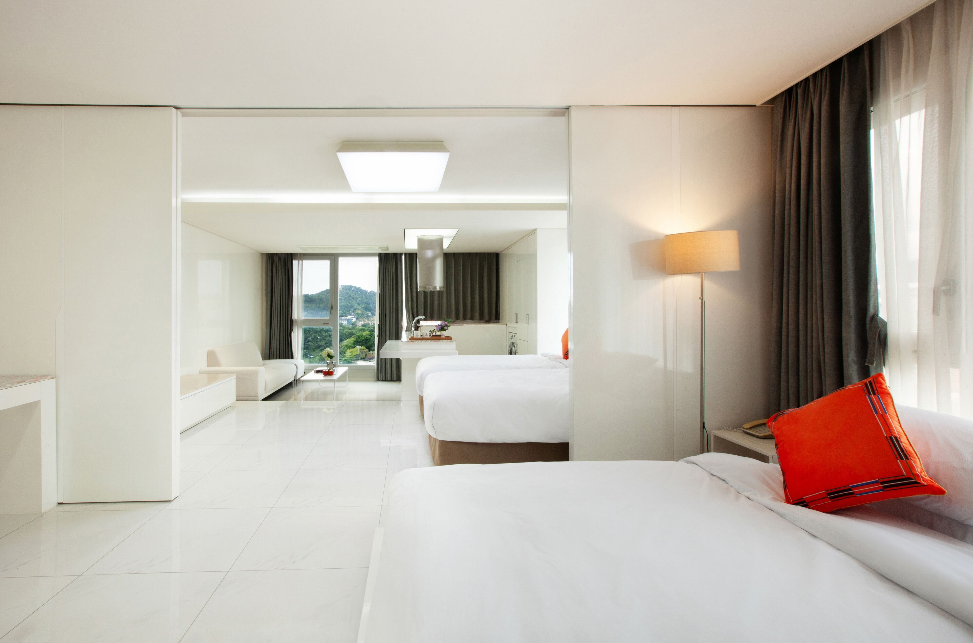 Una habitación de hotel moderna con una cama grande, un escritorio y vistas a la ciudad.