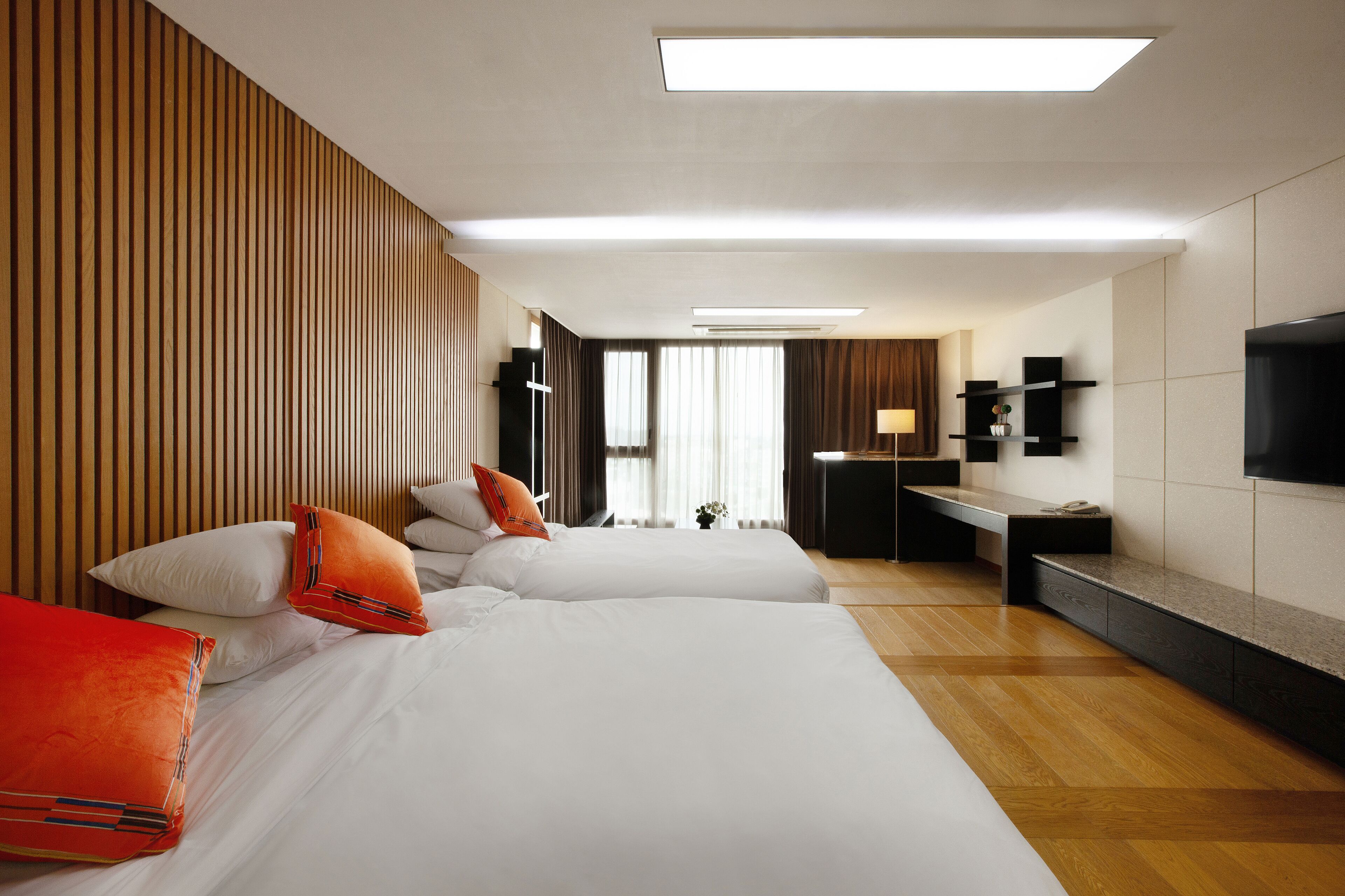 Een hotelkamer met twee bedden, een bureau en een televisie.