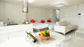 Une chambre d’hôtel moderne dotée d’une cuisine, d’un coin repas et d’un espace de vie.