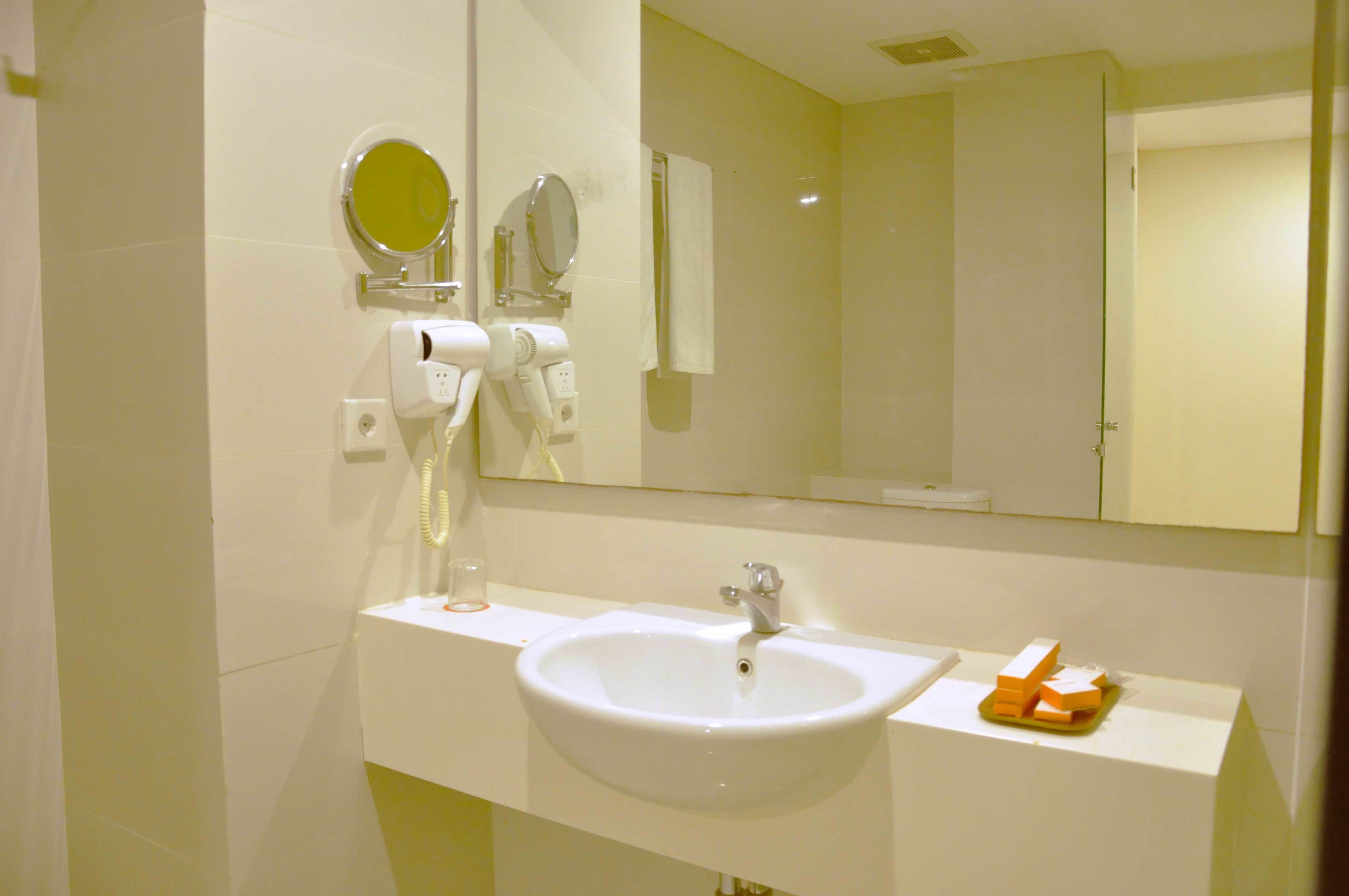 A bathroom with a white sink, a mirror, and a towel rack.