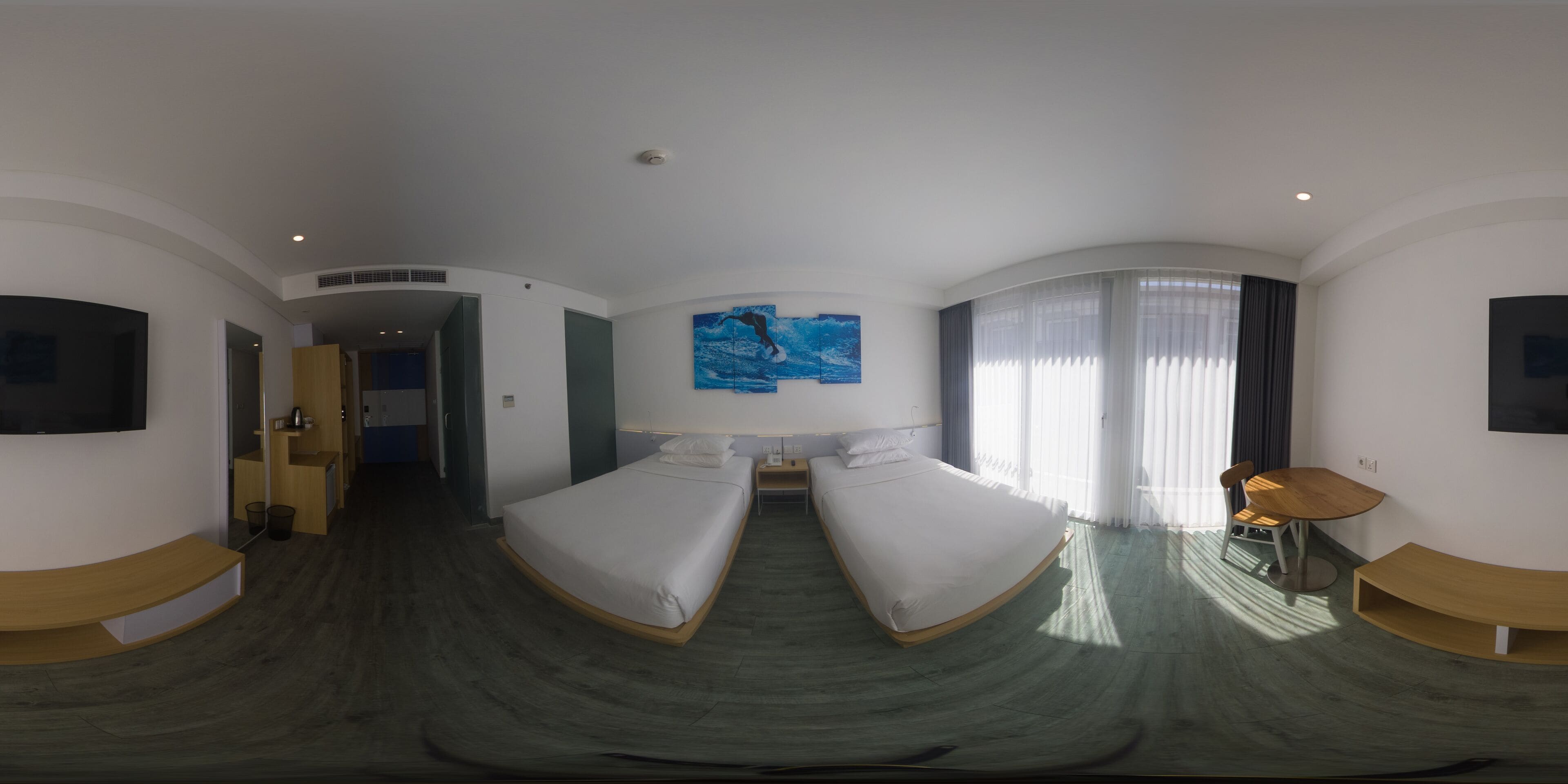 Una habitación de hotel con dos camas, un cuadro, un televisor y un escritorio.