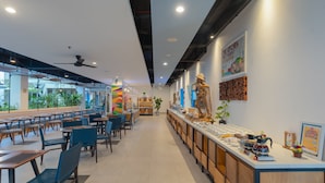 Ein modernes Restaurant mit einer langen Theke, blauen Stühlen und einem Deckenventilator.