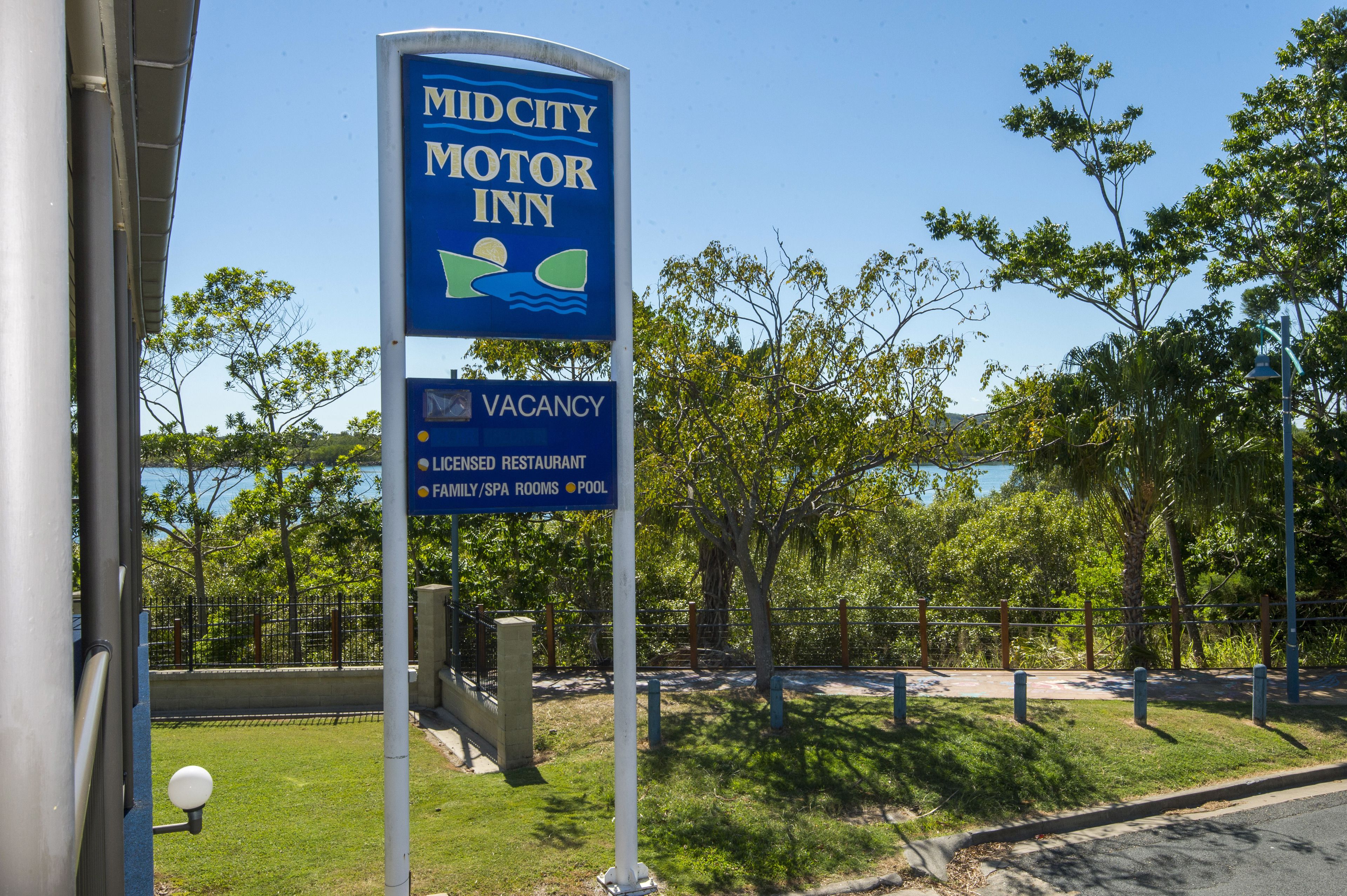 A sign for Midcity Motor Inn indicating a vacancy, a licensed restaurant, family/spa rooms, and a pool.