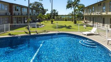 Een buitenzwembad en ligstoelen