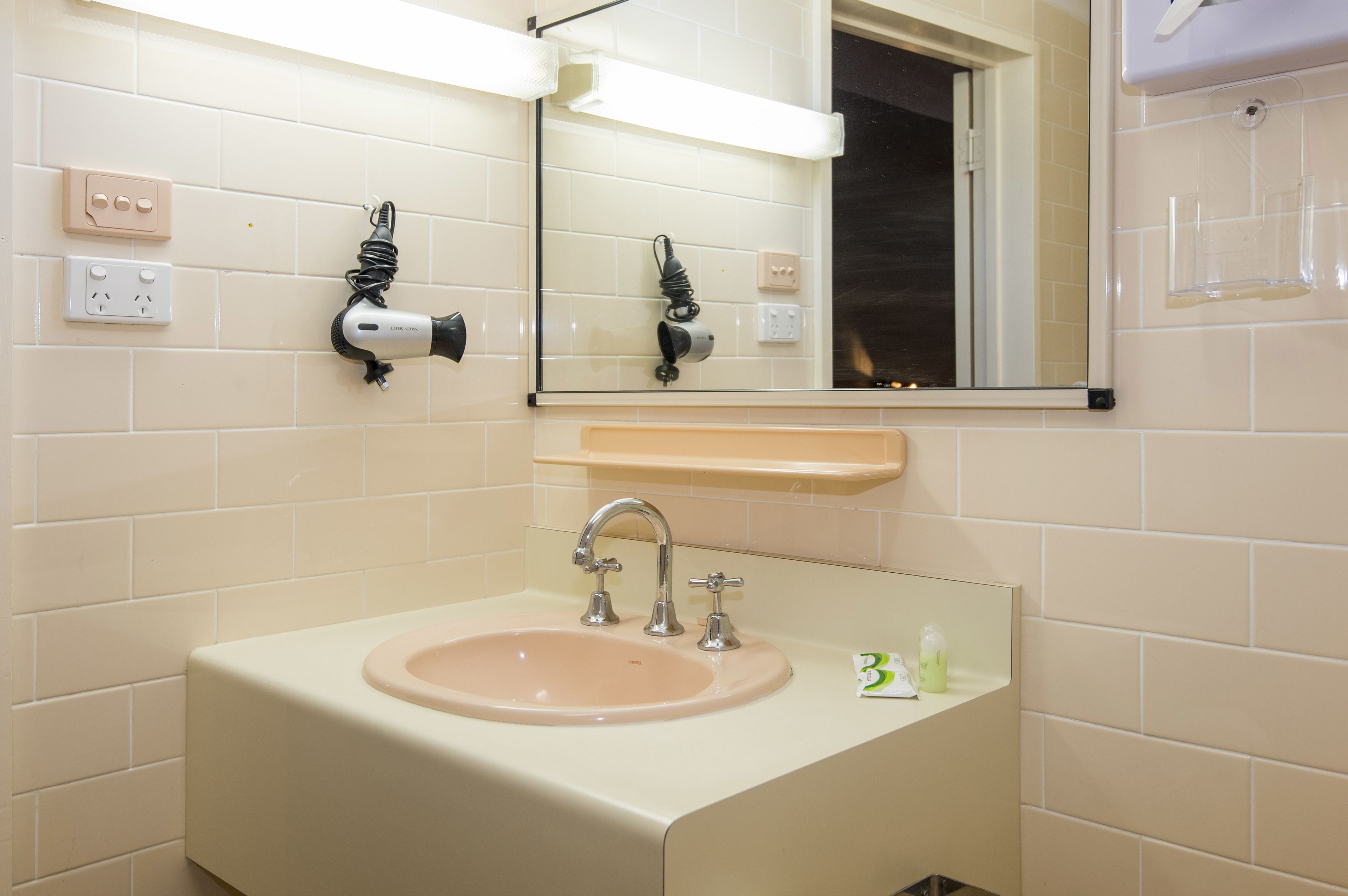 A bathroom with a sink, mirror, and towel rack.