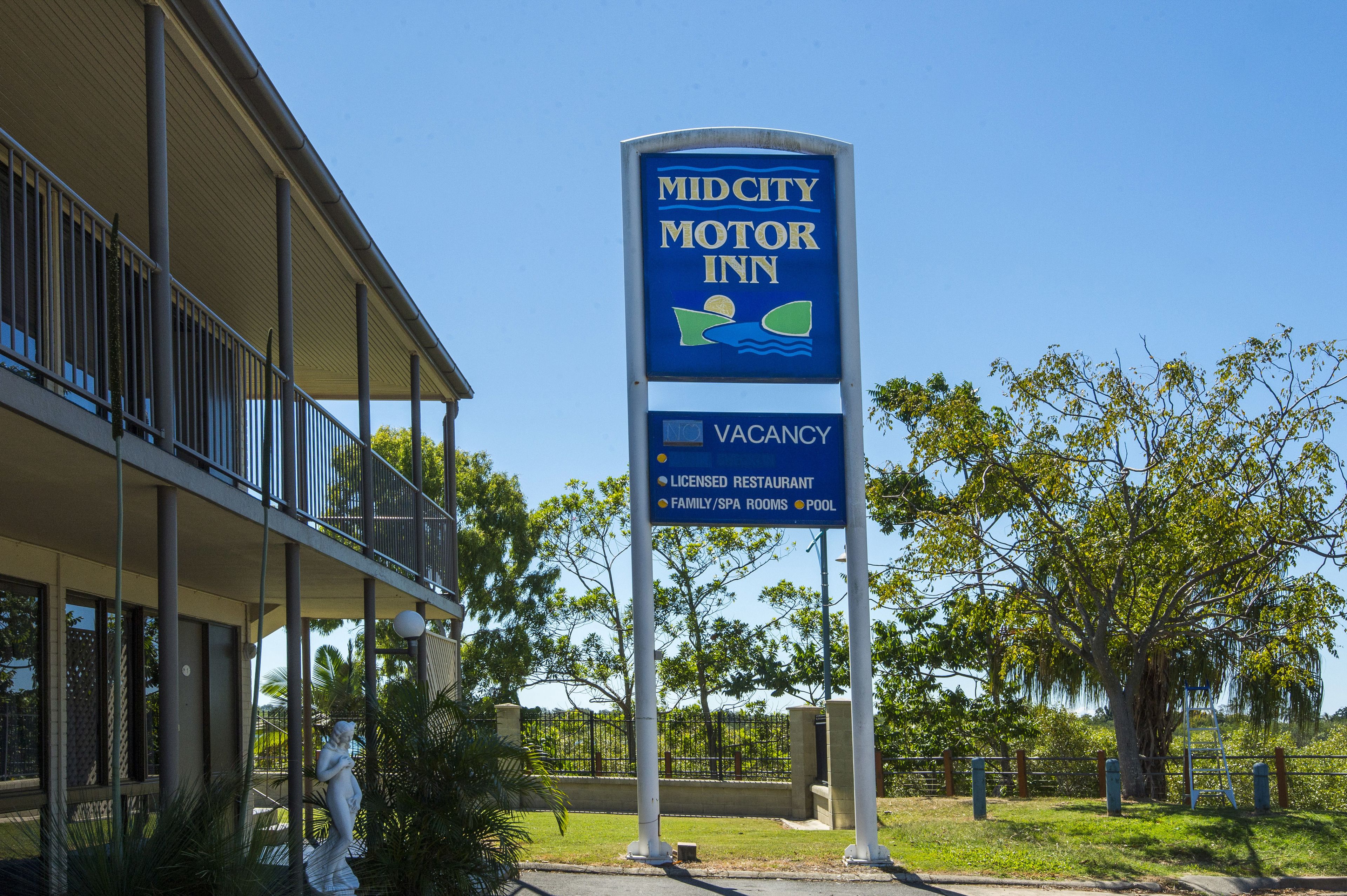 Cartell de MidCity Motor Inn que anuncia restaurant amb llicència, habitacions per a famílies/spa i una piscina.