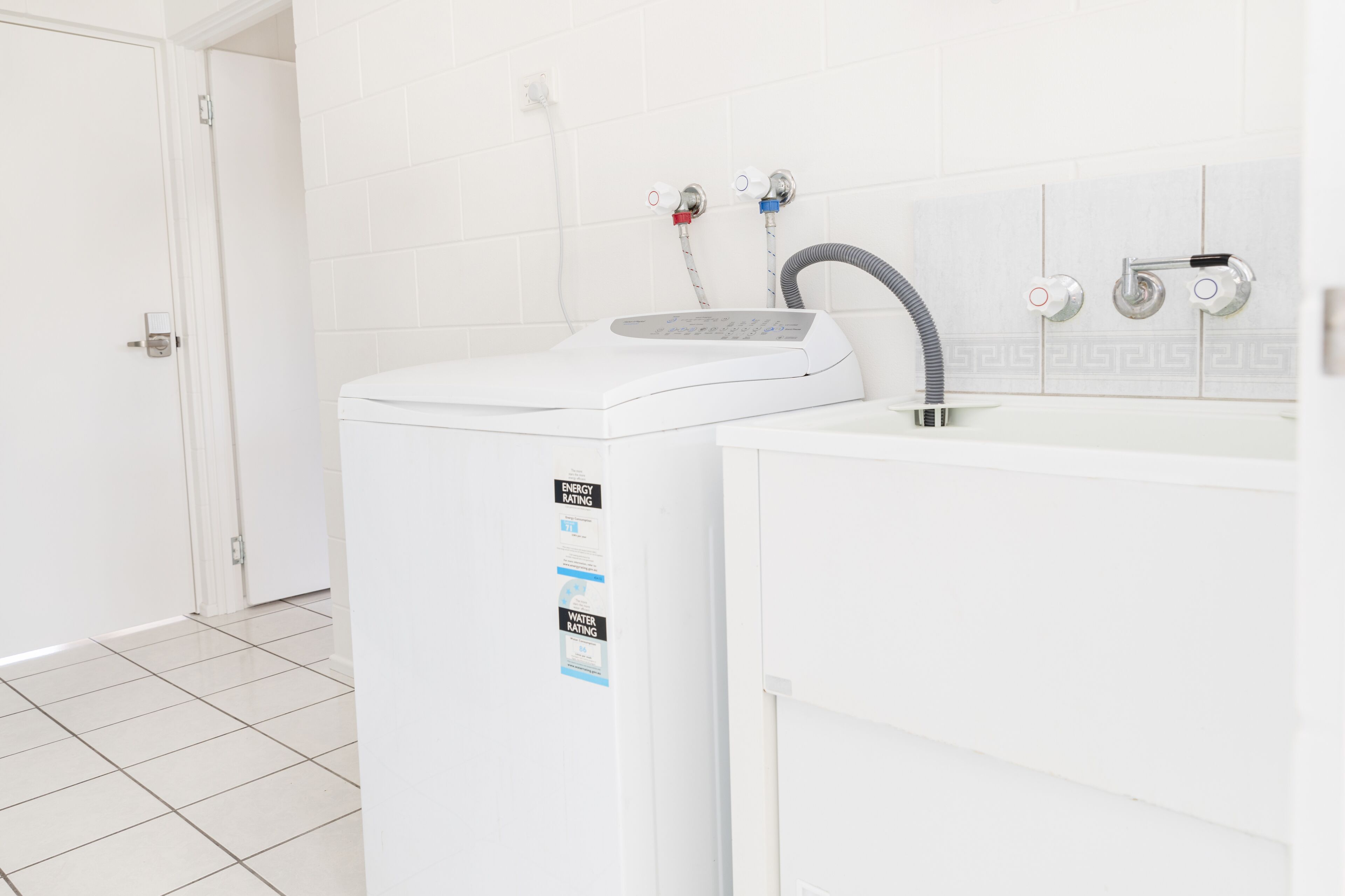 A white washing machine with a control panel and a water rating sticker.