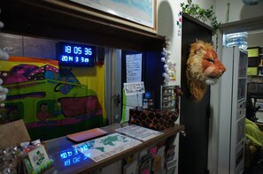 A room with a colorful mural, a digital clock, a calendar, and a lion head decoration. - Hostel BASE POINT Osaka (Osaka)