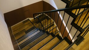 Un escalier en bois avec des rampes noires.
