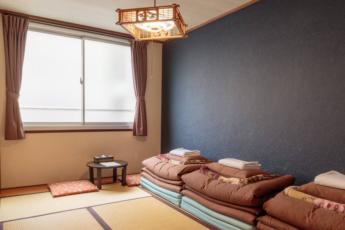 Perinteinen japanilainen huone, jossa on tatamimatto, shoji-liukuovi ja futon-patja.