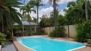 A rectangular swimming pool with a tiled edge, surrounded by a brick patio. - Alexandra Park Motor Inn (Bundaberg West)
