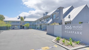 Un motel moderno con un cartello che riporta la scritta '306 Motel Carpark'.