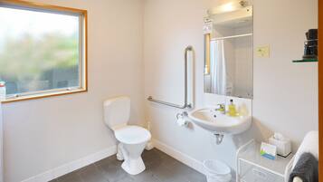 Ein modernes Badezimmer mit Toilette, Waschbecken und Haltestange.