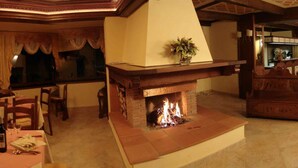 Un comedor acogedor con chimenea, muebles de madera y vista a la cocina.