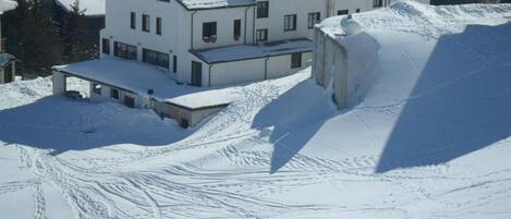 A large, multi-story building with a snow-covered roof and surrounding snow.
