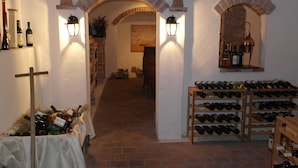 Una bodega con arcos de ladrillo, estanterías para vino y botellas.