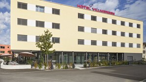 A hotel with a yellow facade, multiple windows, and a sign reading "HOTEL VILLMERGEN". - Villmergen Swiss Quality Hotel (Villmergen)