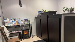 A modern kitchen with a built-in fireplace, a dining area with a wooden chair, and a small table.