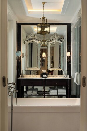 A luxurious bathroom with a large mirror, a chandelier, and a bathtub. - The Hermitage, A Tribute Portfolio Hotel, Jakarta (Jakarta)