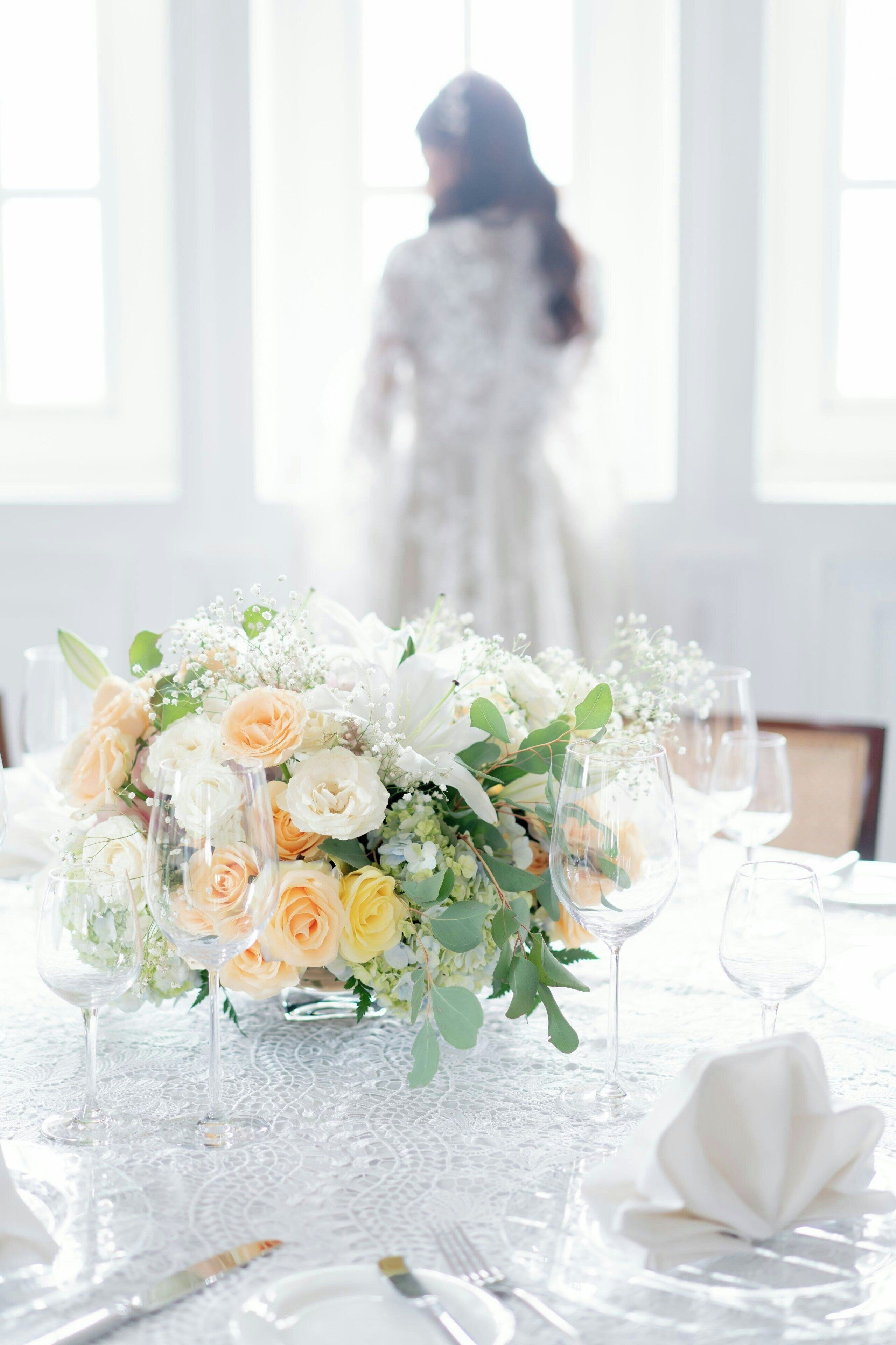 A table set with a floral centerpiece, clear glassware, and white napkins.